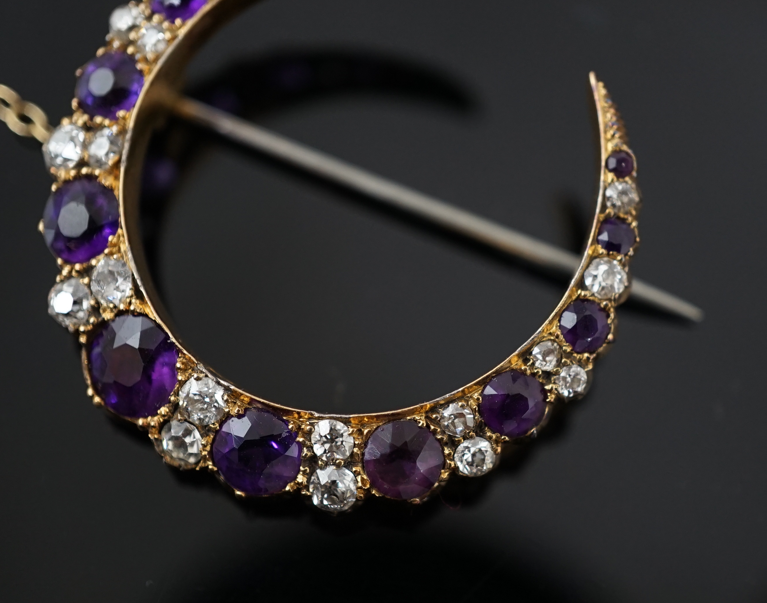 A late Victorian gold, graduated amethyst and diamond cluster set crescent brooch